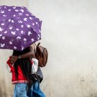 Una pareja pasea con un paraguas en un día de lluvia.