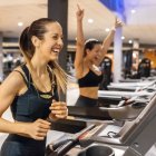 Dos mujeres corren en la cinta en un gimnasio
