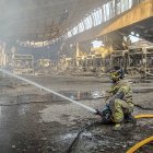 Un bombero sofica el incendio en las cocheras municipales de Burgos, que ha perdido más de la mitad de la flota.
