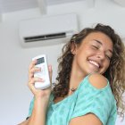 Una chica disfruta del aire acondicionado en su casa