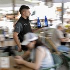 Un camarero atiende a clientes en un bar de Valencia.