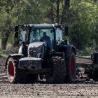 Un agricultor realiza labores de campo con su tractor.