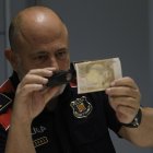 Imagen de archivo (2/11/2023) en la que el jefe de la Unidad Central de Falsificación de Moneda de los Mossos d' Esquadra, Sergi Sánchez, comprueba la autenticidad de un billete durante la entrevista con EFE en Barcelona. EFE/ Quique García.
