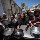 Palestinos desplazados esperan comida caliente, ayer.