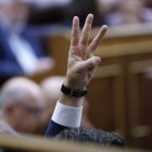 Un diputado levanta tres dedos para indicar qué votar durante el pleno, este jueves, en el Congreso de los Diputados.
