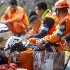 Rescatistas de El Salvador descansan en medio de las labores de búsqueda de supervivientes a los terremoto.