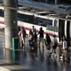 Un grupo de pasajeros camina en el andén para subir a su tren