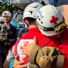 Dos bomberos se abrazan tras el rescate.