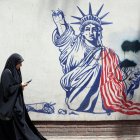 Una mujer pasa junto a un mural en la antigua embajada de EE UU en Teherán.