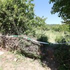Acceso a la finca de cerezos con el precinto judicial donde apareció el cuerpo golpeado del vecino de Arganza.