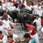 Los toros de la ganadería sevillana de Miura entran en la curva de Mercaderes durante el séptimo encierro de los Sanfermines 2026, este lunes en Pamplona. EFE/Jesús Diges.