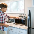Hombre pone en orden y deja los electrodomésticos de la cocina antes de las vacaciones.