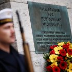 Una placa junto a una corona de flores dice  «Aquí murieron por Alemania el 20 de julio de 1944...» durante un acto en memoria de quienes fueron asesinados por su resistencia a la tiranía nazi en el Bendlerblock de Berlín, Alemania, este lunes.  EFE/EPA/CLEMENS BILAN.