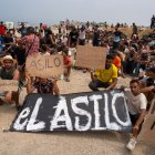 Un grupo de migrantes concentrados para solicitar asilo este domingo en la playa del trampolín de Ceuta.