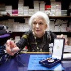 Dolores Agra, propietaria de la lencería Marta, en el barrio coruñés de Os Castros, muestra la medalla al Mérito por el Trabajo, concedida cuando superó los 61 años de cotización.