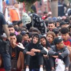 Migrantes frente a la explanada de embotellamiento de Loma Colmenar.