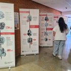 Dos personas observan la exposición de la Asociación Española Contra el Cáncer en el Hospital El Bierzo