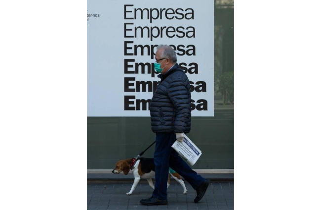 Una persona camina con su perro por la Gran Vía de Barcelona, este martes. ENRIC FONTCUBERTA