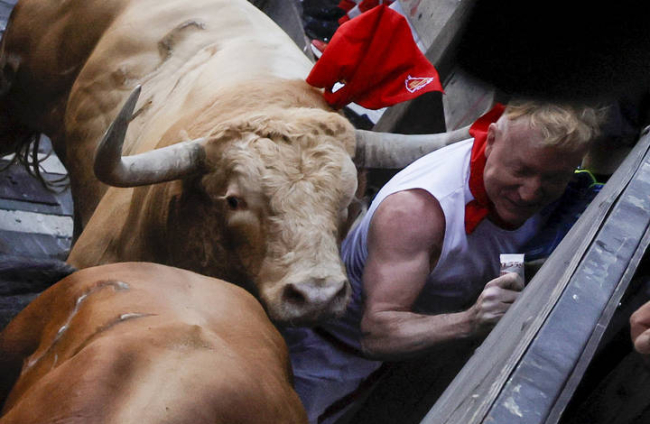 Un hombre es alcanzado por los toros en el primer encierro de los Sanfermines 2022. JESÚS DIGES