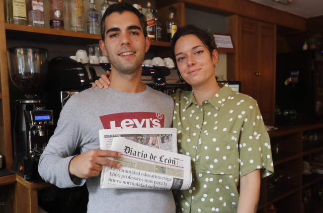 Isaac y Grisela posan con el Diario de León en el interior de la Cafetería Mittaca, un lugar donde nunca falta este periódico. MARCIANO PÉREZ