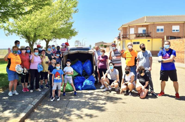 Imagen de los voluntarios con la basura recogida este sábado en Laguna de Negrillos. DL