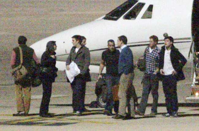 William, con jersey azul y Harry, con camisa a cuadros, en el aeropuerto.