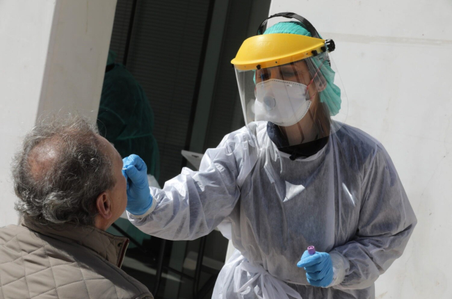 Profesionales sanitarios protegidos con batas, máscaras y guantes, efectúan pruebas para detectar el coronavirus. EFE