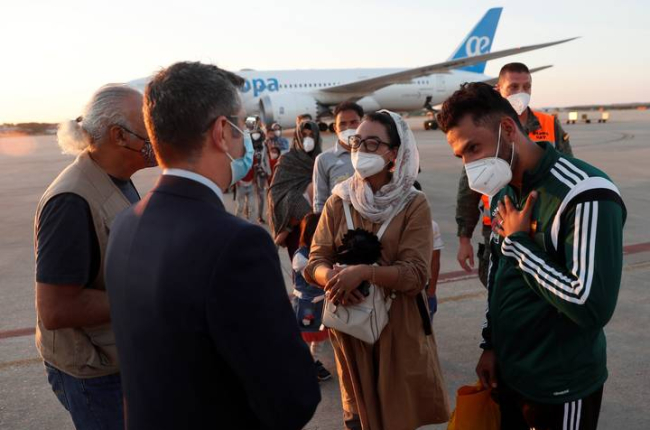 El ministro de la Presidencia, Félix Bolaños (2i), da la bienvenida a la jugadora afgana de baloncesto en silla de ruedas Nilofar Bayat (c) y a su marido (d) en la base aérea militar de Torrejón de Ardoz (Madrid), donde hoy viernes ha aterrizado el segundo avión fletado por España para evacuar a españoles y afganos del país asiático con 110 personas, entre ellas tres familias completas de personal de la Embajada. EFE/Mariscal POOL