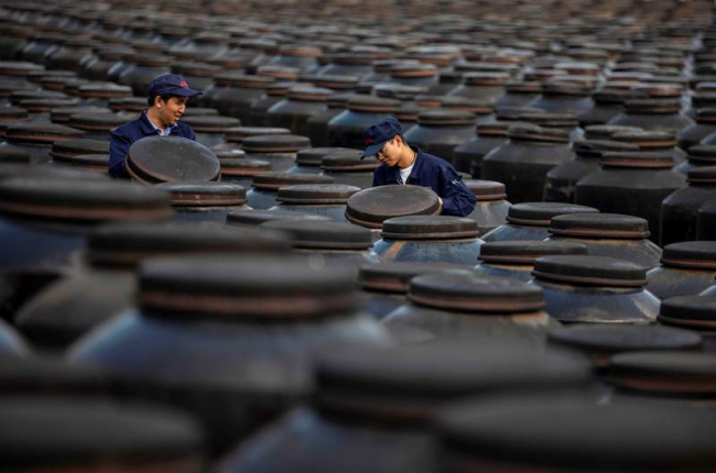Dos empleados revisan barriles de vinagre en una de las fábricas de Zhenjiang. ALEX PLAVEVSKI