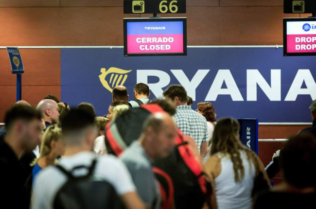 Un grupo de pasajeros hacen cola para facturar en la aerolínea Ryanair. ENRIC FONTCUBERTA