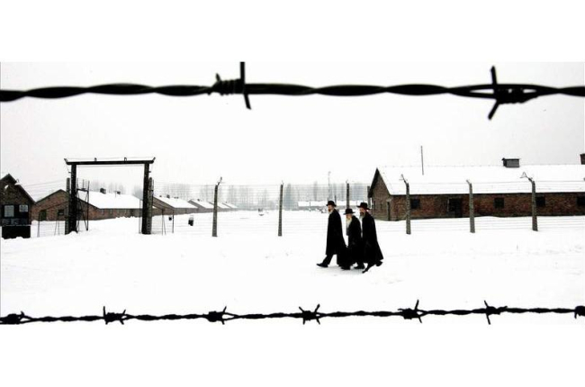 Tres judíos caminan por el campo de concentración de Auschwitz, donde se celebró solo una boda hace 70 años.