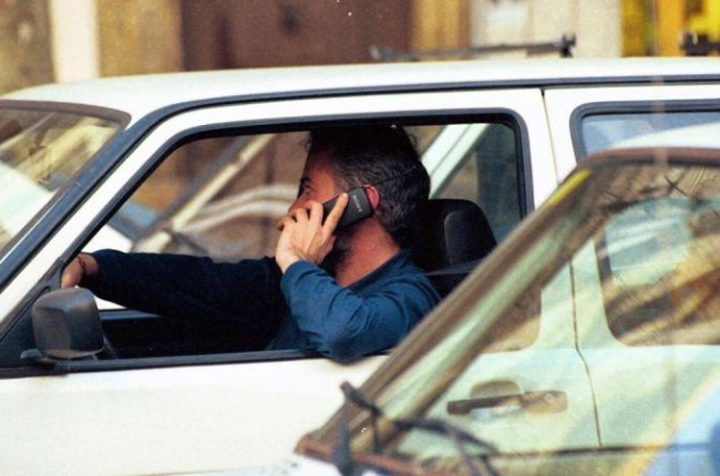 Un hombre habla por teléfono móvil al volante.