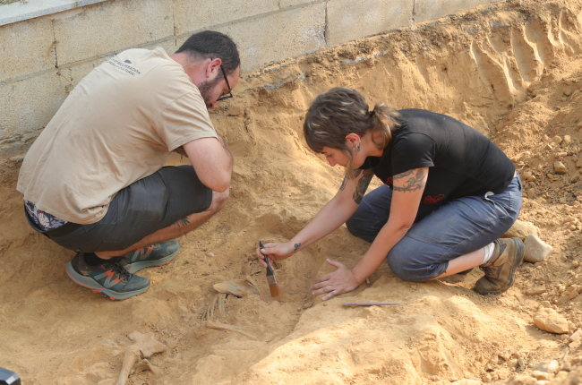 Dos miembros de Sputnik Labrego limpian superficialmente los restos óseos localizados. L. DE LA MATA.