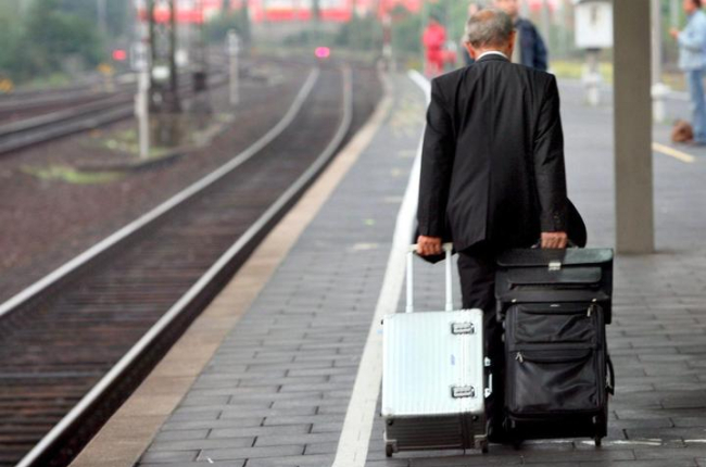 Un hombre arrastra sus maletas por el andén de una estación de tren. MARTIN GERTEN