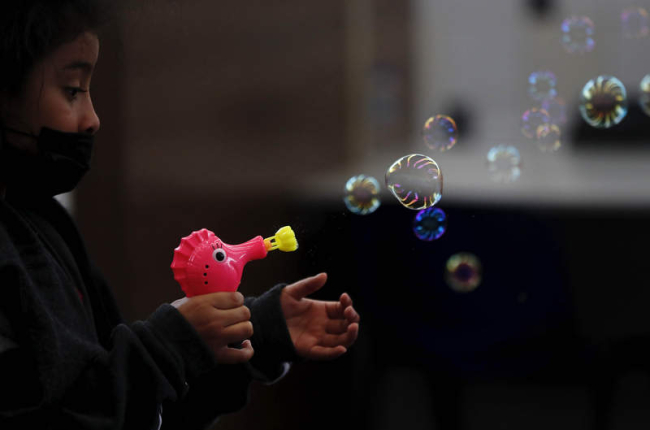 Una niña juega con una pistola de burbujas. ESTEBAN BIBA