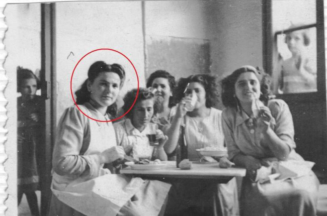 Antonia, con el círculo rojo, tomando un piscolabis con compañeras del hospicio. Las pequeñas las contemplan desde la ventana