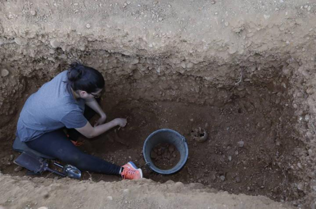 Una voluntaria de la ARMH limpia los restos de la tumba aledaña a la de Genara, que resultó ser de un hombre. MARCIANO PÉREZ
