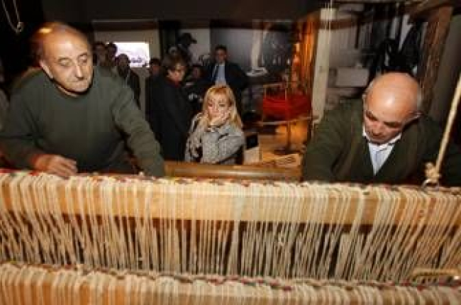 Dos expertos artesanos del pueblo maragato y tejedor de Val de San Lorenzo manejan el telar expuesto