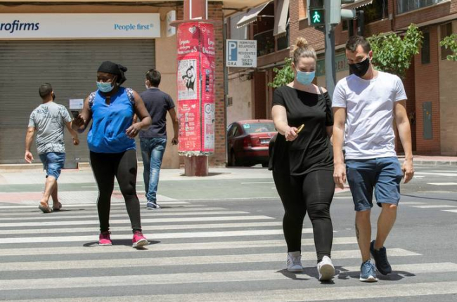 Varias personas con mascarilla cruzan un paso de peatones este lunes en la Avenida de Europa de Lorca. MARCIAL GUILLÉN