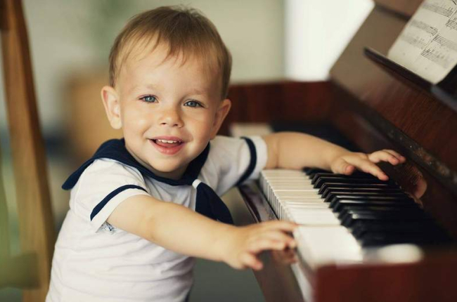 Un niño de tres años tocando el piano. DL
