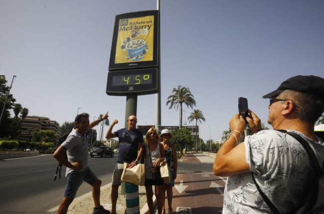 Los turistas se hacen fotografías debajo de un termómetro a 45 grados ayer en Córdoba. SALAS