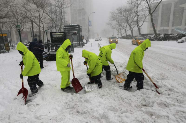 Unos trabajadores retiran nieve en las cercanías del Lincoln Center en Nueva York.
