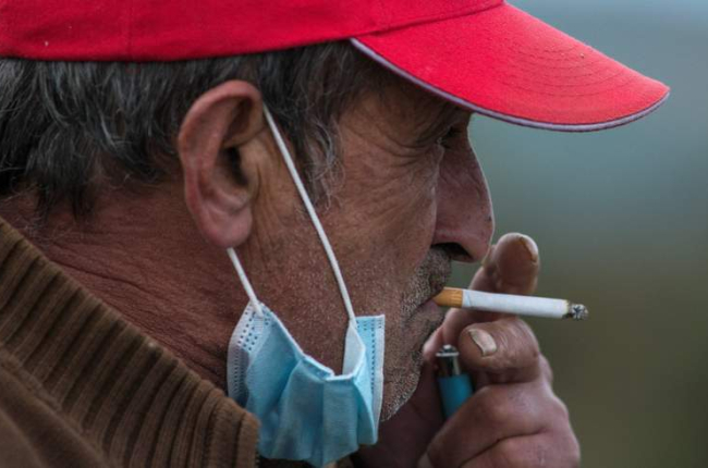 Un hombre fuma en Barcelona con la mascarilla bajada. BRAIS LORENZO