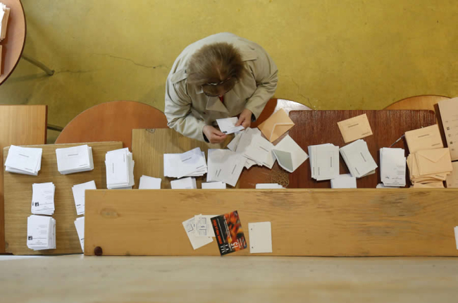 Una persona eligiendo papeleta para votar en el transcurso de una jornada electoral. FERNANDO OTERO