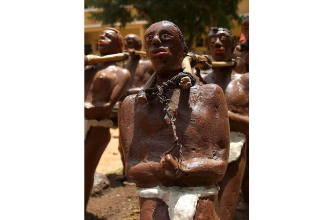 Una escultura de Lamine Barro representa una escena de esclavos encadenados.