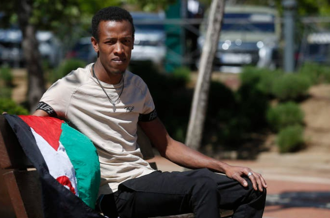 Mohamed Salek Abeid posa con la bandera saharaui en un banco de un parque de León. FERNANDO OTERO