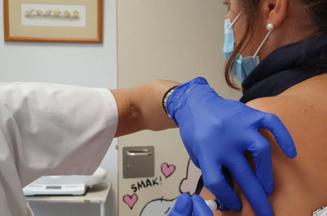 Una mujer se vacuna contra la gripe. DL