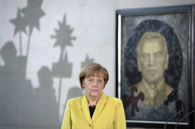 La canciller alemana, Angela Merkel, ante un retrato del excanciller Gerhard Schroeder durante una recepción, hoy, en Berlín.
