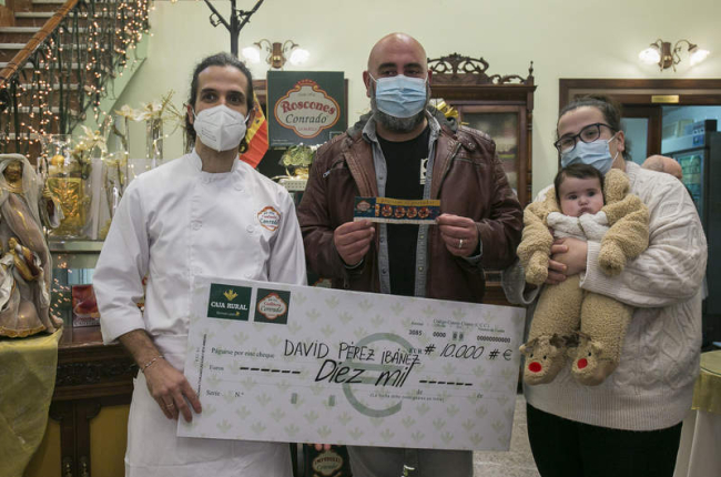 David Pérez y su familia recogen el cheque de manos de Manuel González. DL