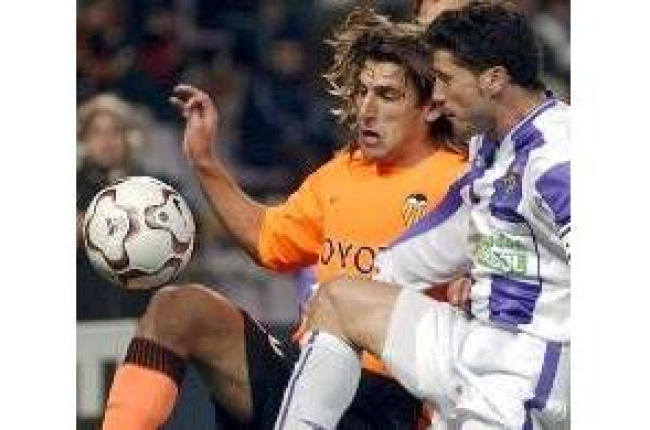 El capitán del Valladolid, Torres Gómez, pugna con el valencianista Miguel Ángel por un balón